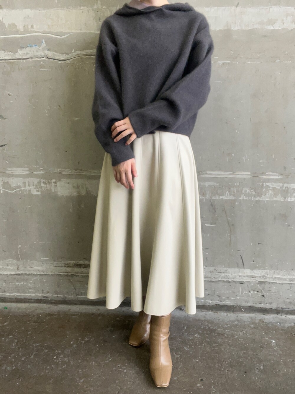 ベージュ系のブーツ、グレー系のパーカー、ホワイト系のスカートを着用したレディースの秋コーディネートの7枚目の写真
