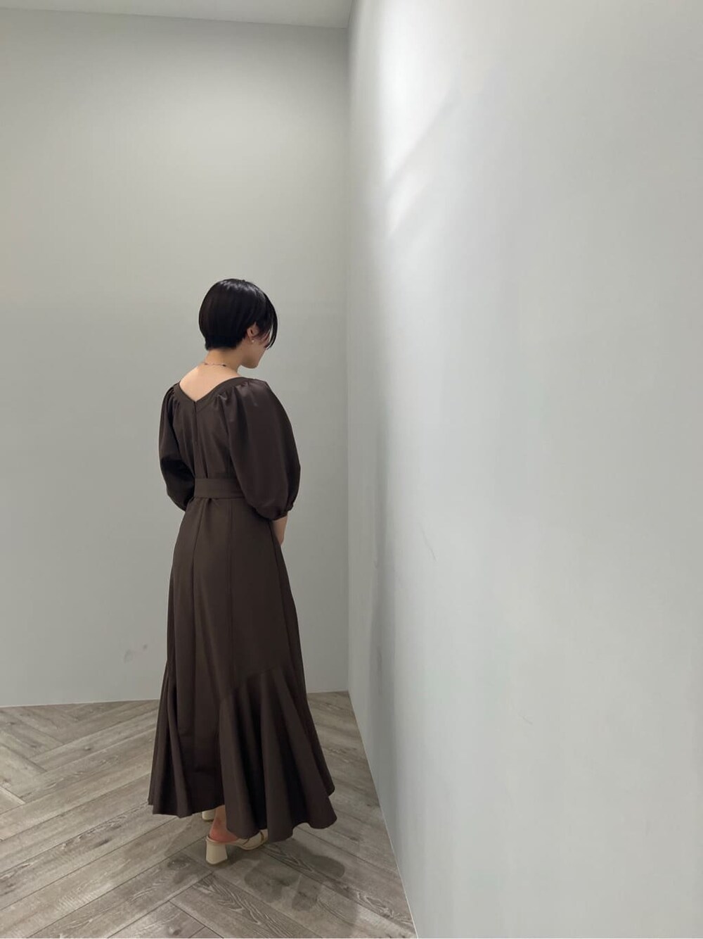 ホワイト系のサンダル、ブラウン系のワンピース、ホワイト系のショルダーバッグを着用したレディースの夏コーディネートの4枚目の写真