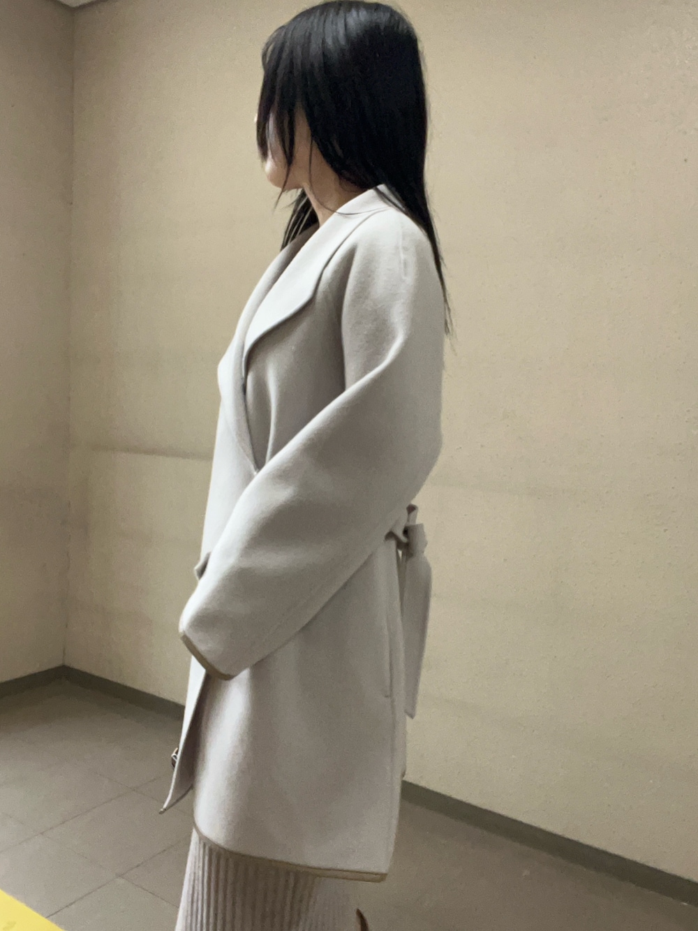 ブラック系のブーツ、ベージュ系のワンピース、ホワイト系のその他アウターを着用したレディースの秋コーディネートの4枚目の写真