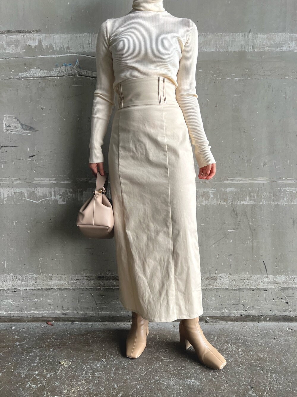 イエロー系のカーディガン/ボレロ、ベージュ系のブーツ、ホワイト系のニット/セーターを着用したレディースの秋コーディネートの7枚目の写真