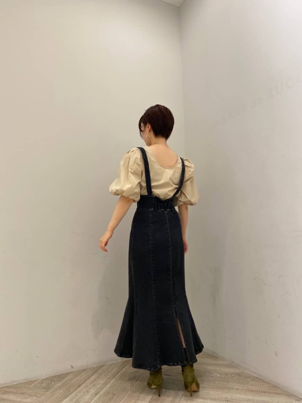 ベージュ系のシャツ/ブラウス、ブラック系のスカート、ベージュ系のブーツを着用したレディースの夏コーディネートの5枚目の写真