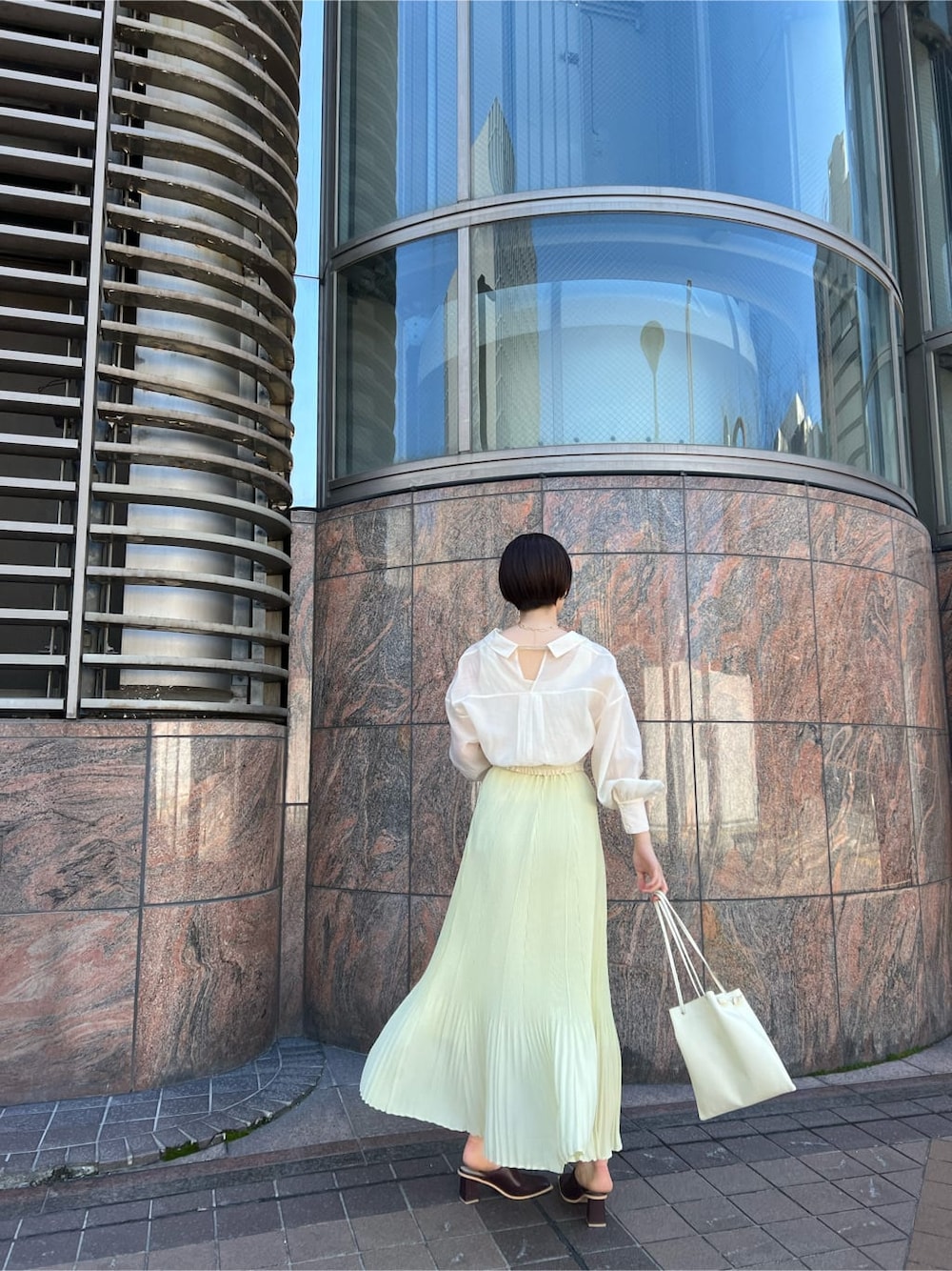 ホワイト系のシャツ/ブラウス、イエロー系のスカート、ホワイト系のハンドバッグを着用したレディースの春コーディネートの3枚目の写真