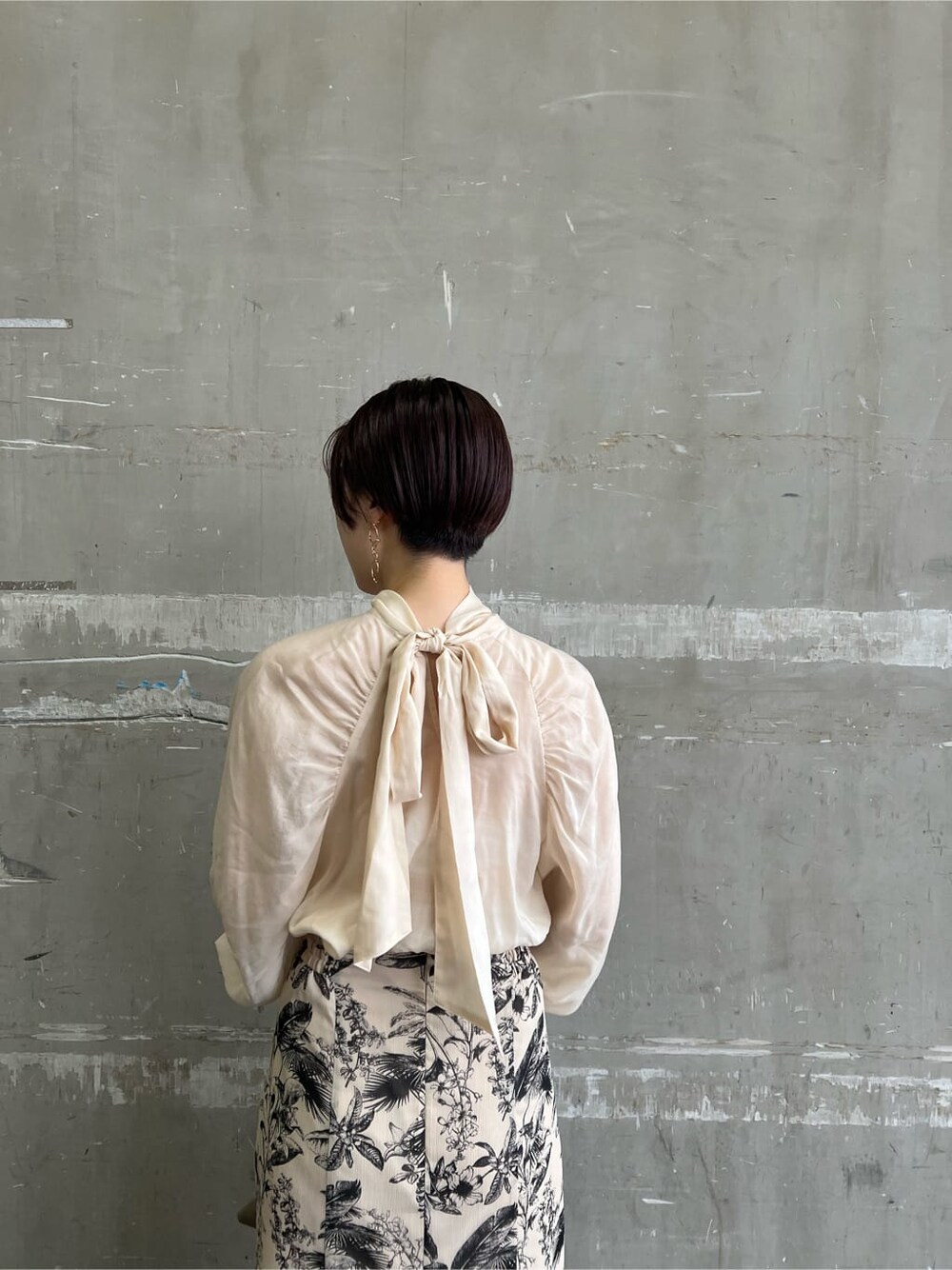 ベージュ系のハンドバッグ、ベージュ系のスカート、ブラウン系のシャツ/ブラウスを着用したレディースの夏コーディネートの6枚目の写真