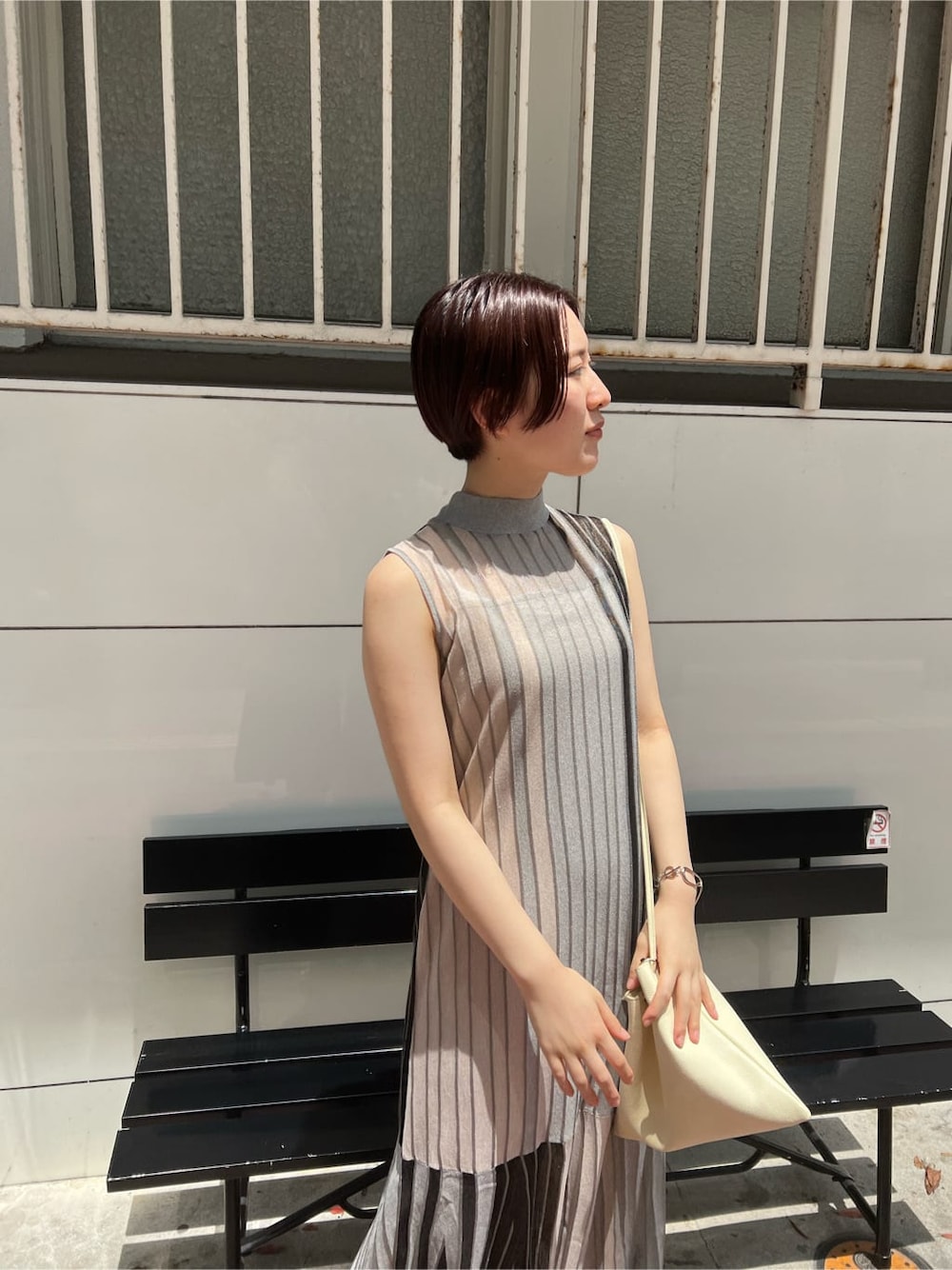 ホワイト系のハンドバッグ、グリーン系のサンダル、ブラック系のワンピースを着用したレディースの夏コーディネートの2枚目の写真