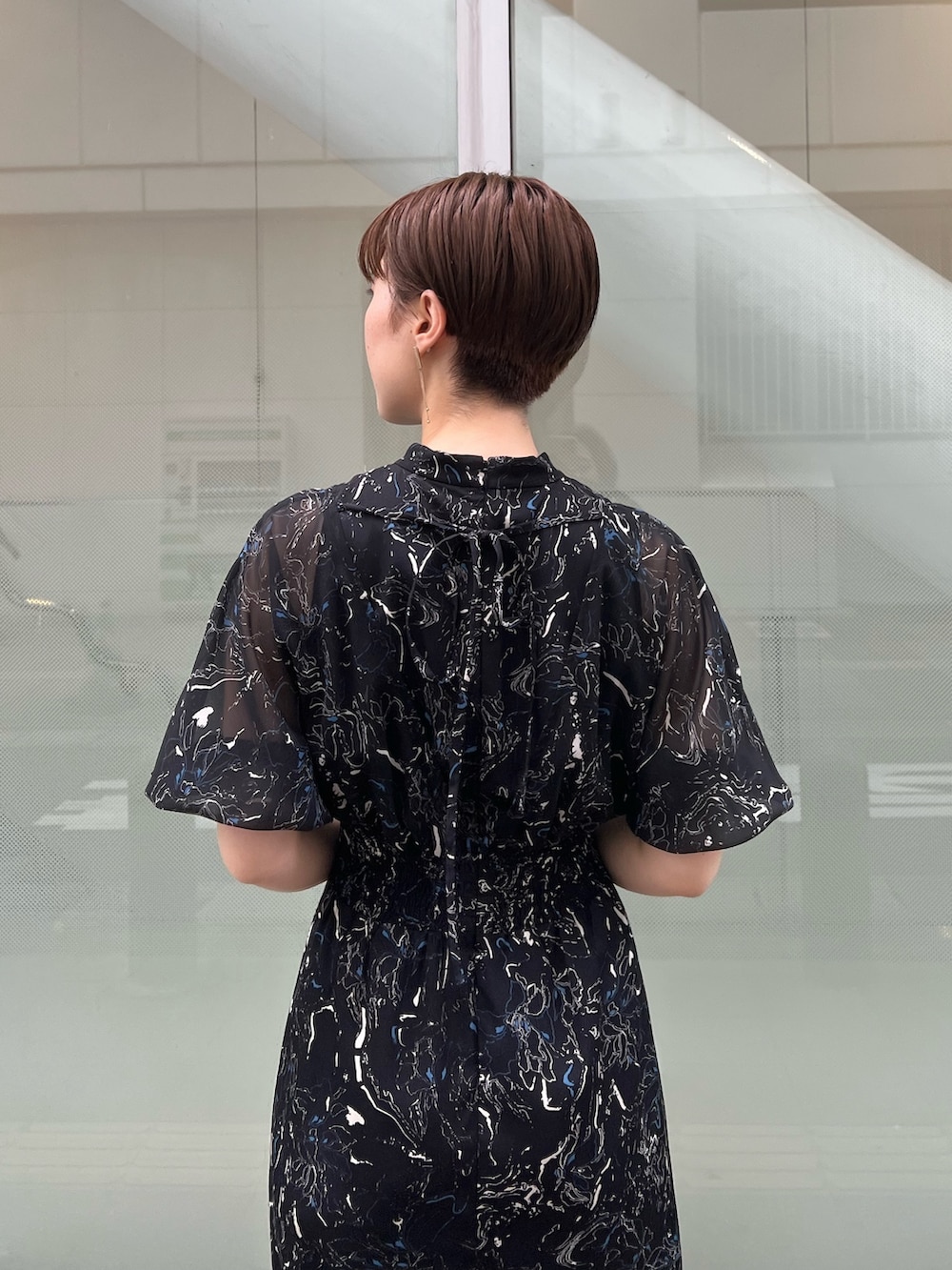 ベージュ系のサンダル、ホワイト系のハンドバッグ、ブラック系のワンピースを着用したレディースの夏コーディネートの4枚目の写真