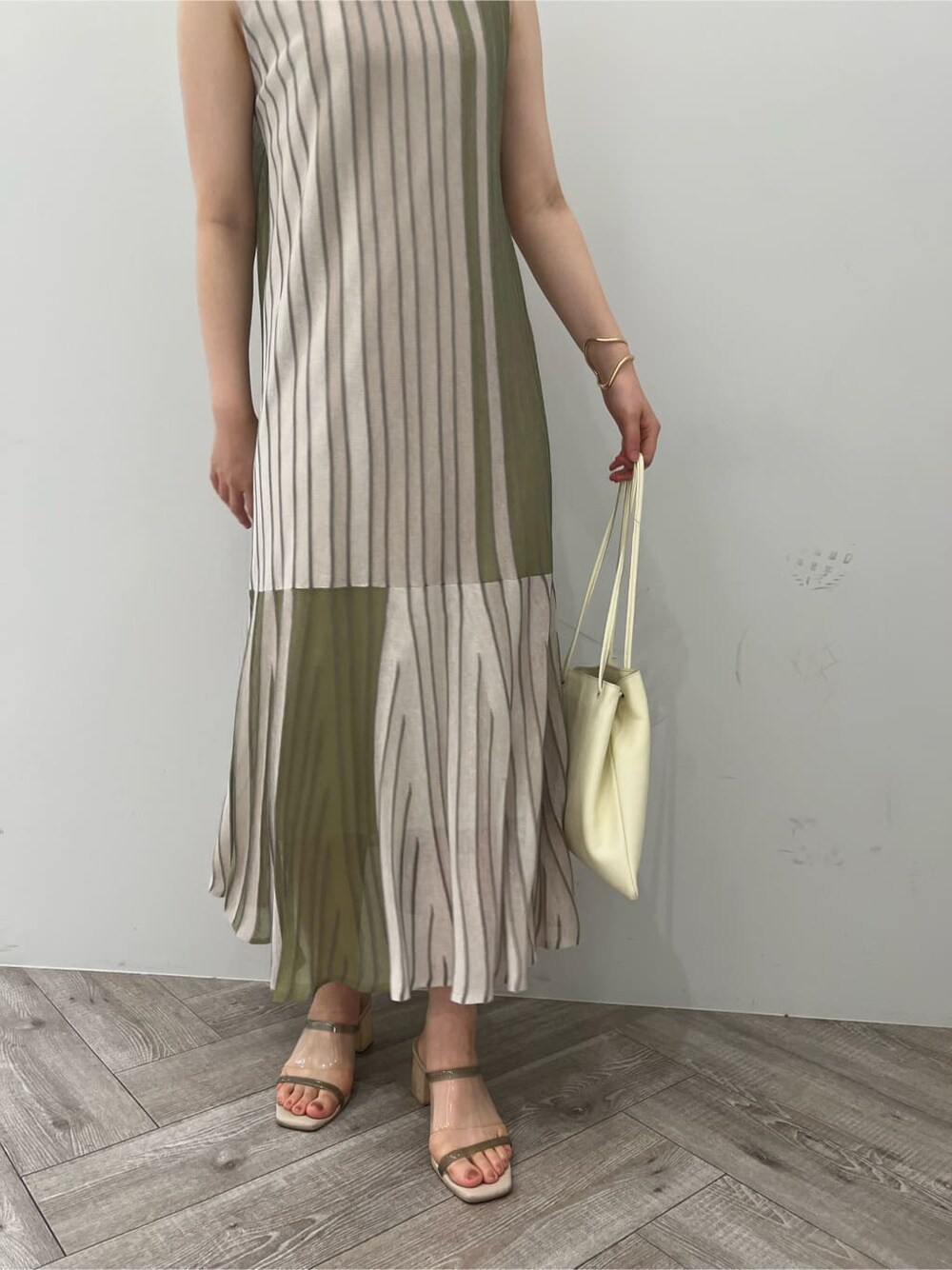 グリーン系のワンピース、グリーン系のサンダル、ゴールド系のピアス（両耳用）を着用したレディースの夏コーディネートの8枚目の写真