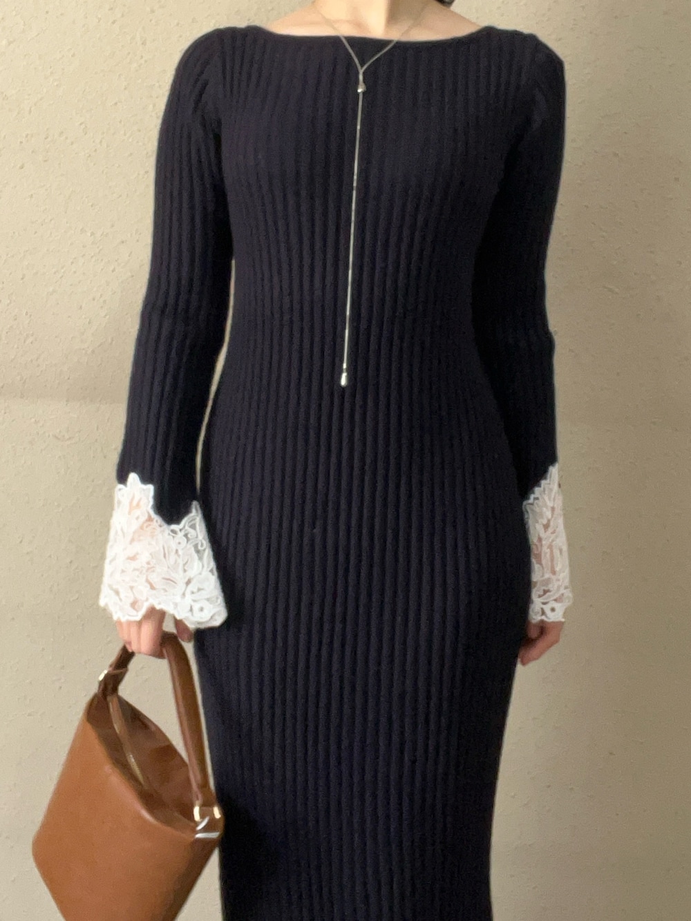 イエロー系のハンドバッグ、ブルー系のワンピース、ブラック系のブーツを着用したレディースの秋コーディネートの4枚目の写真