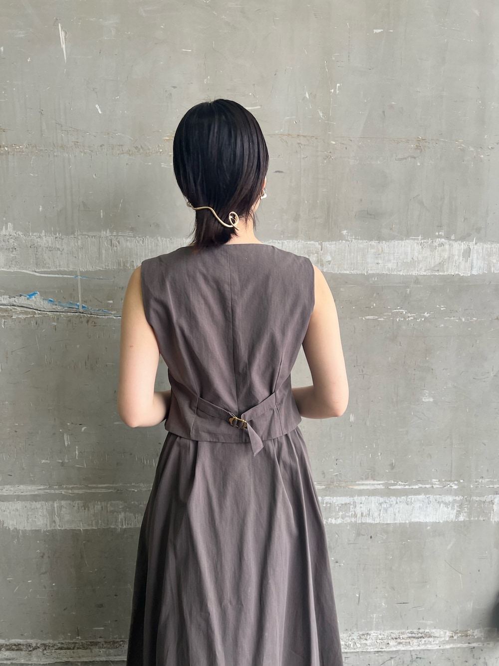 グレー系のワンピース、ブラック系のハンドバッグ、ブラック系のサンダルを着用したレディースの夏コーディネートの5枚目の写真