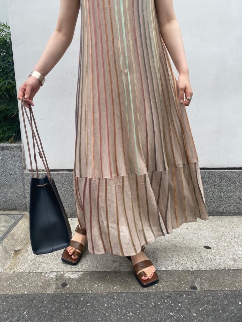 ブラック系のハンドバッグ、ブラウン系のサンダル、ベージュ系のワンピースを着用したレディースの夏コーディネートの5枚目の写真