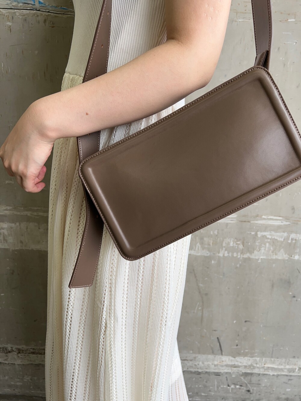 ベージュ系のサンダル、ベージュ系のショルダーバッグ、ホワイト系のワンピースを着用したレディースの夏コーディネートの6枚目の写真