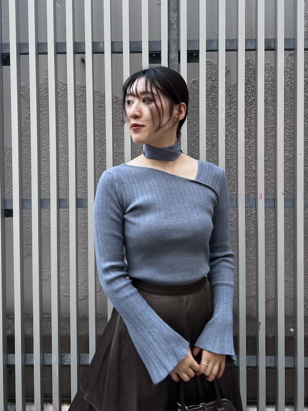 ブルー系のニット/セーター、ブラウン系のスカート、ブラック系のブーツを着用したレディースの秋コーディネートの4枚目の写真