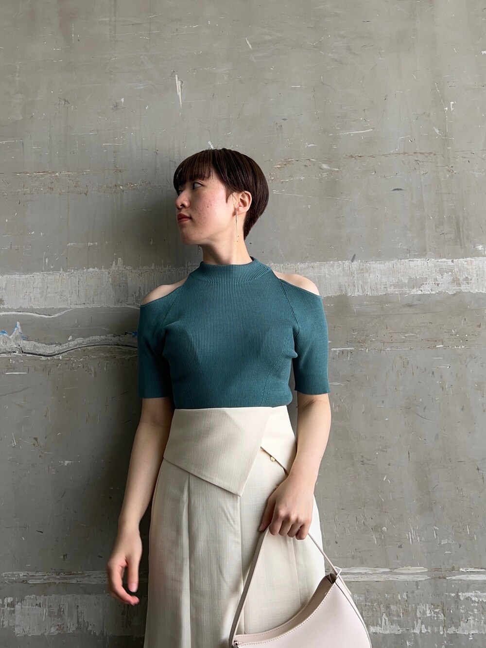 ホワイト系のハンドバッグ、グリーン系のニット/セーター、ホワイト系のスカートを着用したレディースの夏コーディネートの3枚目の写真