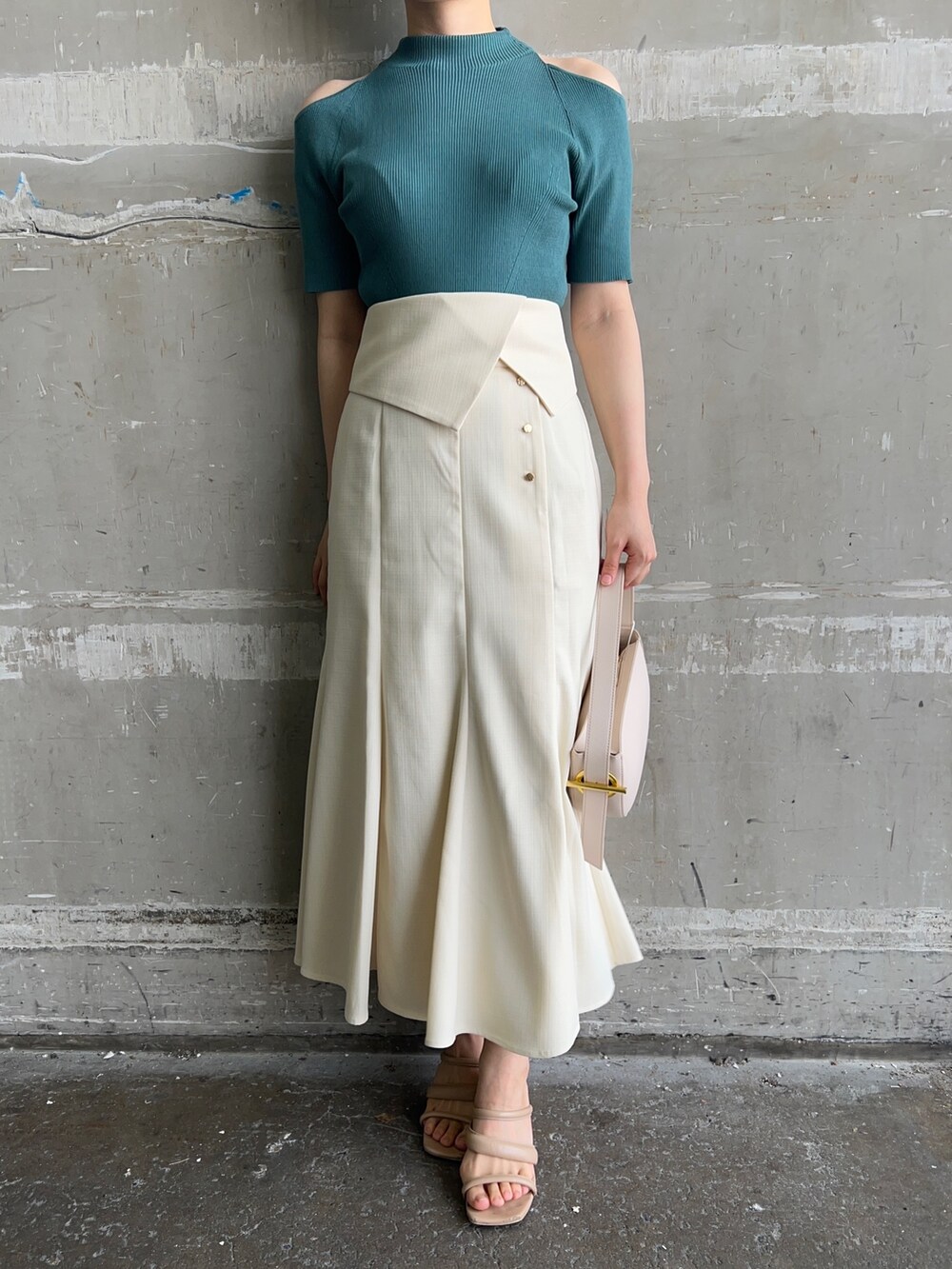 ホワイト系のハンドバッグ、グリーン系のニット/セーター、ホワイト系のスカートを着用したレディースの夏コーディネートの5枚目の写真