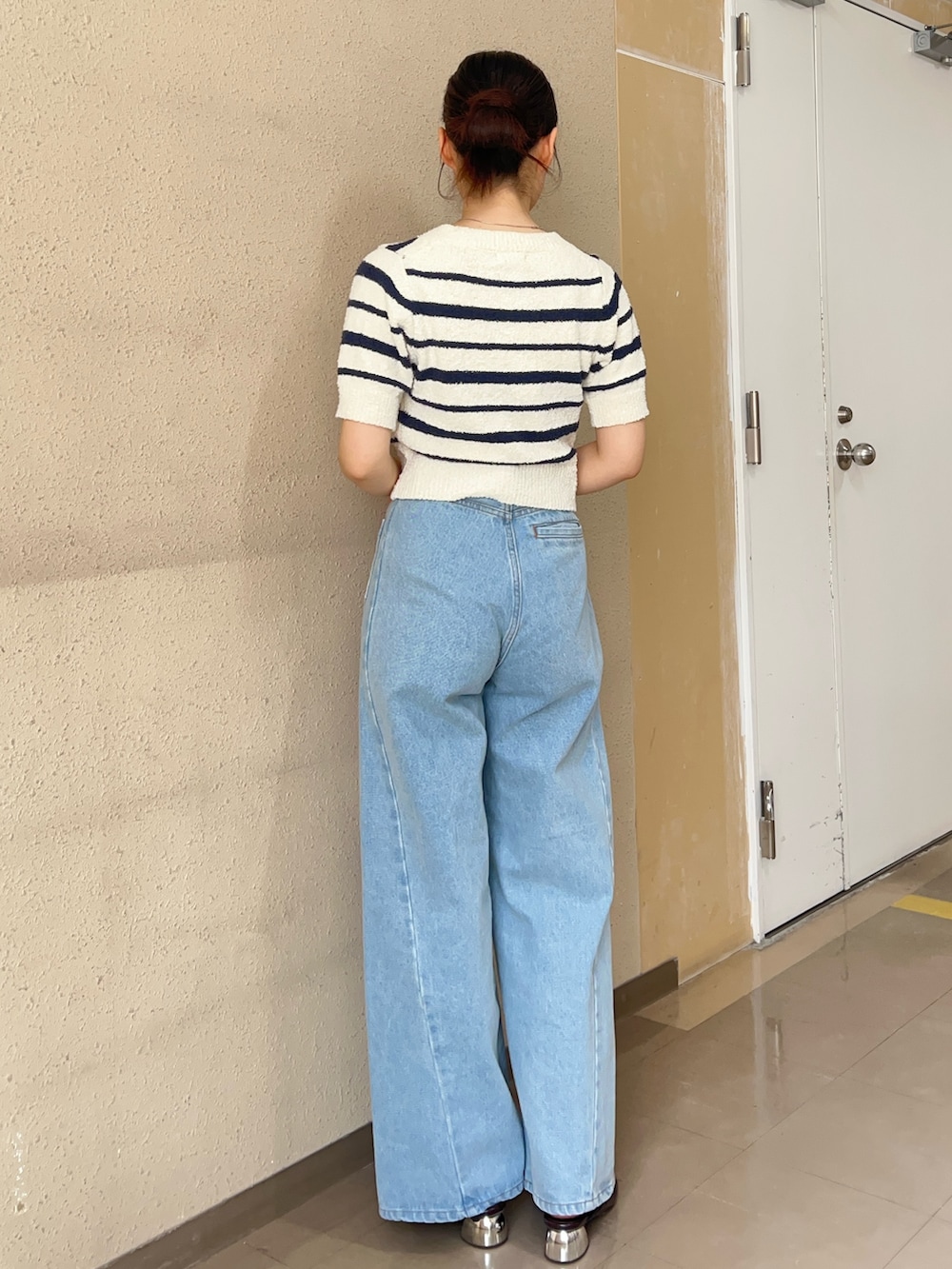 ブルー系のデニムパンツ、ホワイト系のニット/セーター、ブラック系のパンプスを着用したレディースの春コーディネートの3枚目の写真