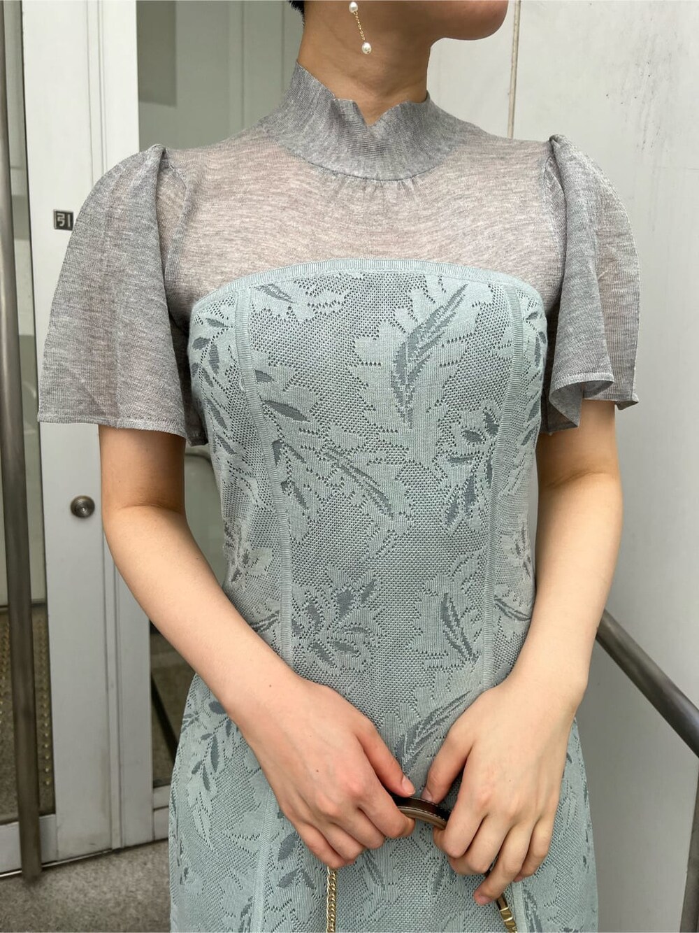 ゴールド系のクラッチバッグ、ゴールド系のパンプス、ブルー系のドレスを着用したレディースの秋コーディネートの5枚目の写真