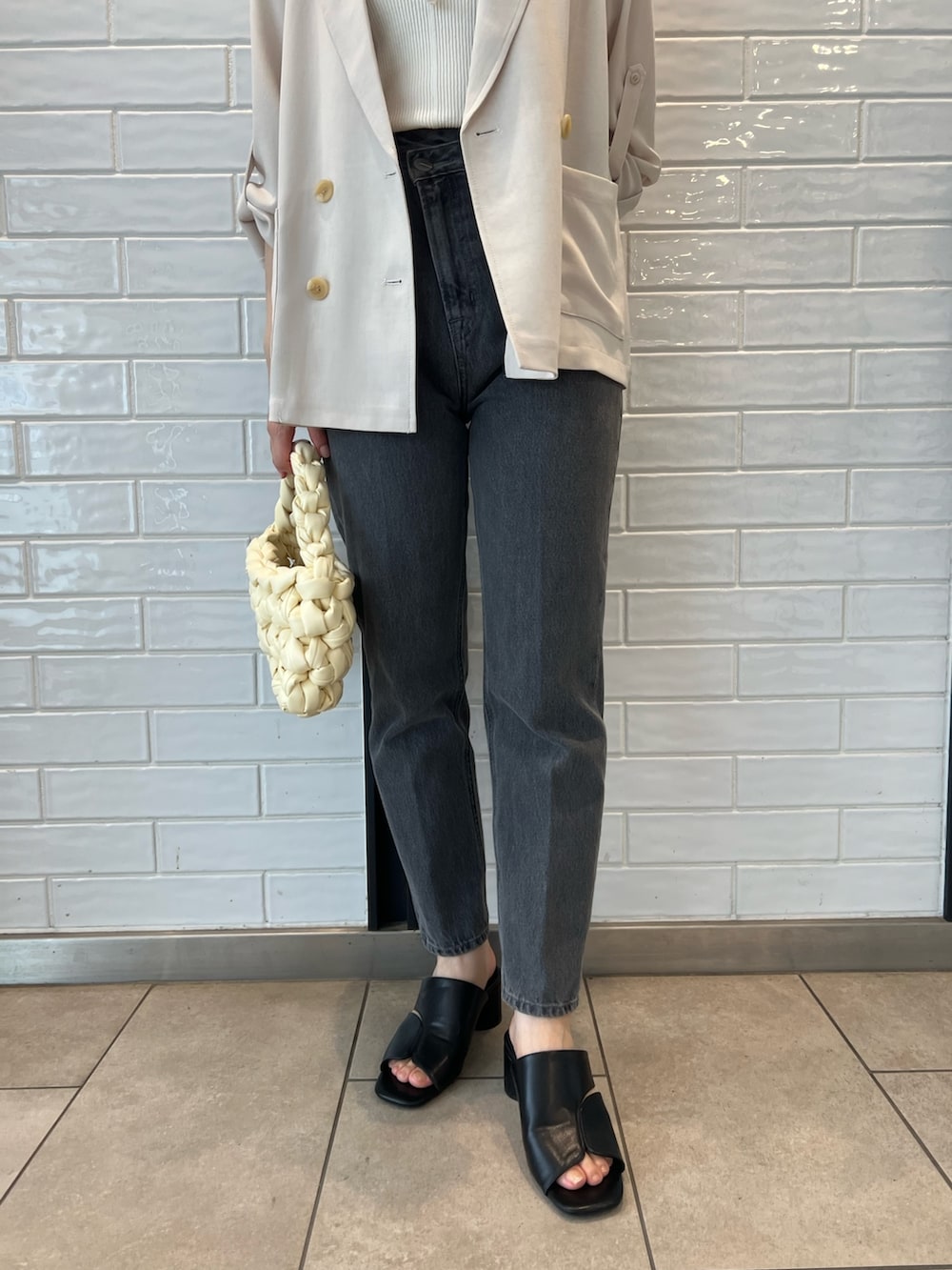 ホワイト系のキャミソール、ブラック系のデニムパンツ、ベージュ系のテーラードジャケットを着用したレディースの夏コーディネートの5枚目の写真