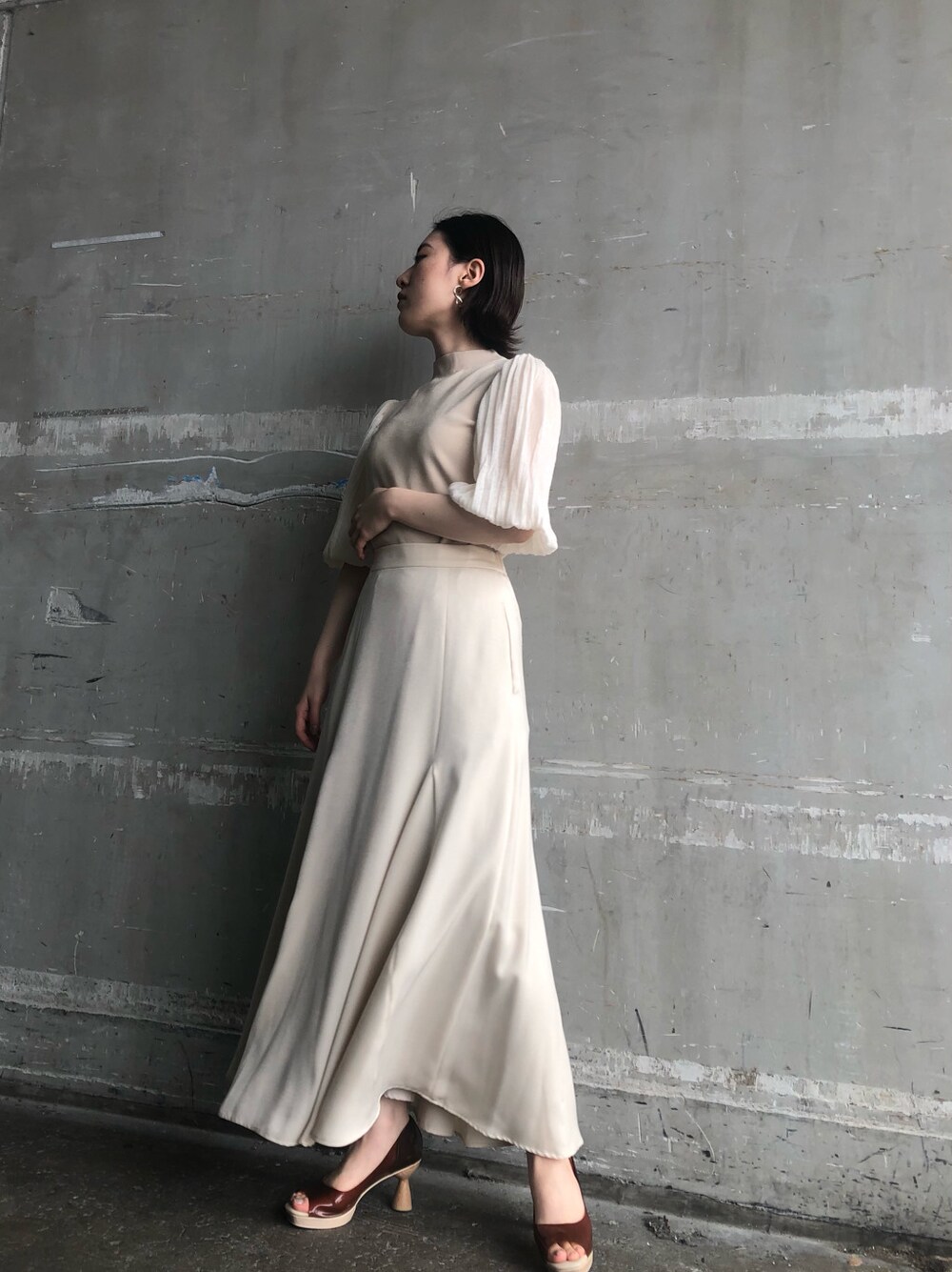 ホワイト系のスカート、ブラウン系のパンプス、ベージュ系のその他アウターを着用したレディースの春コーディネートの2枚目の写真