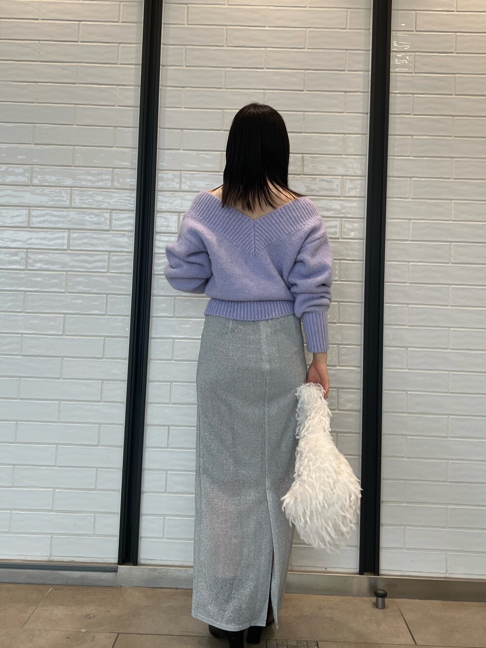 パープル系のニット/セーター、シルバー系のスカートを着用したレディースの冬コーディネートの3枚目の写真