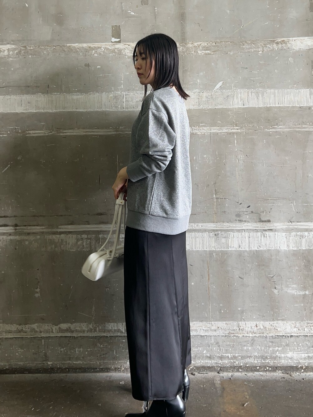 ブラック系のスカート、ブラック系のブーツ、グレー系のスウェットを着用したレディースの秋コーディネートの2枚目の写真