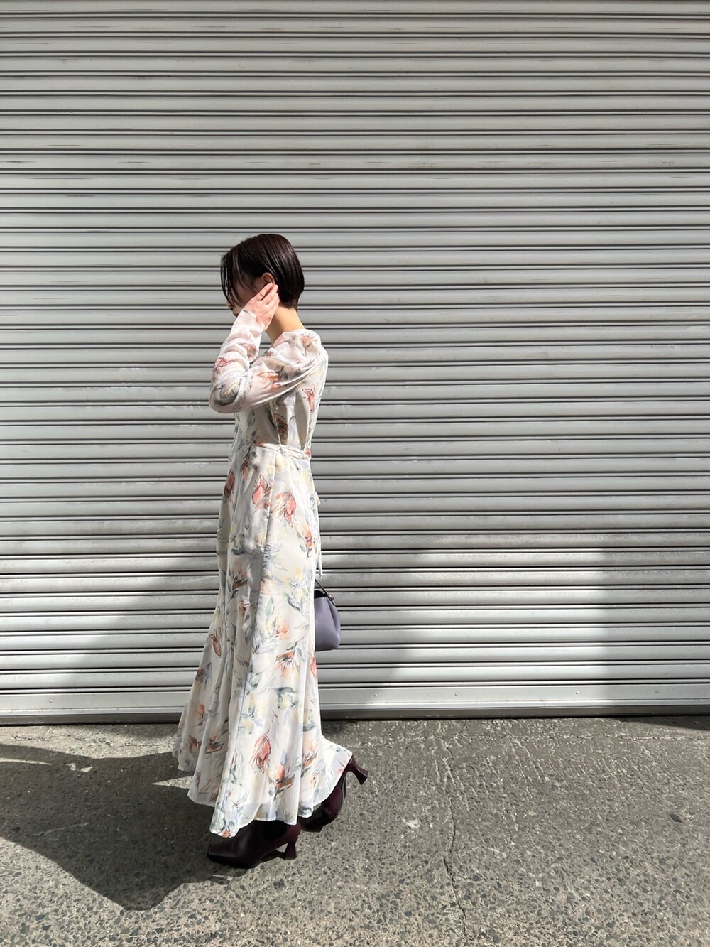 レッド系のブーツ、パープル系のハンドバッグ、ホワイト系のカーディガン/ボレロを着用したレディースの冬コーディネートの7枚目の写真