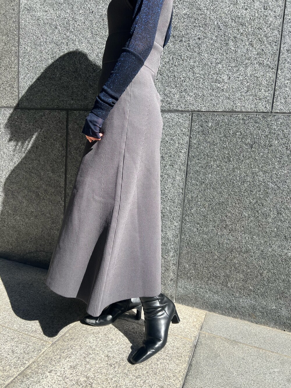 グレー系のTシャツ/カットソー、グレー系のカーディガン/ボレロ、グレー系のジャンパースカートを着用したレディースの秋コーディネートの6枚目の写真