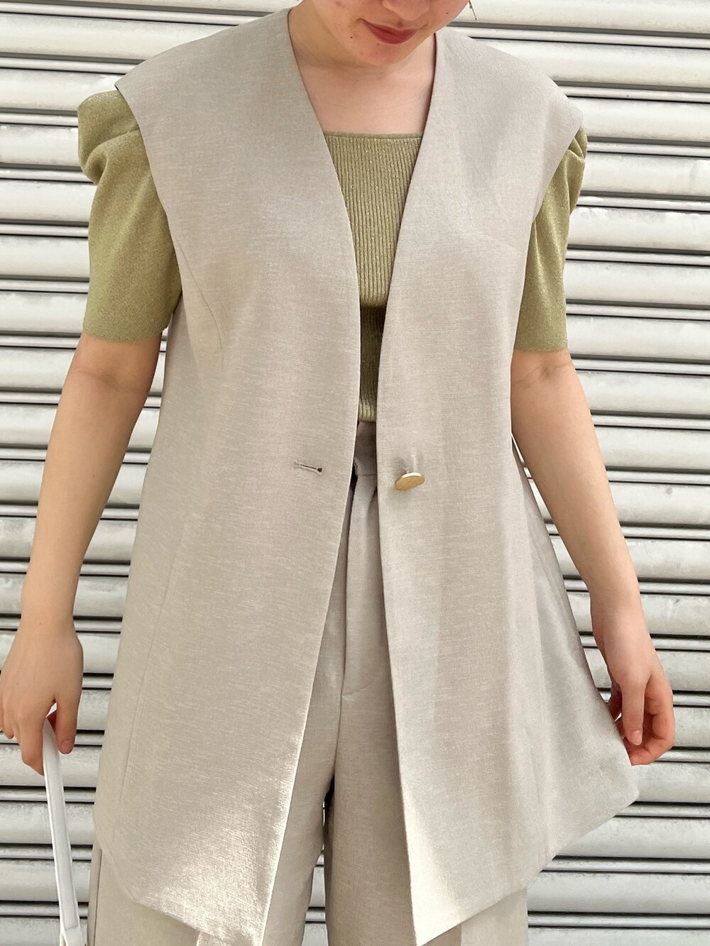 ホワイト系のハンドバッグ、ベージュ系のサンダル、ベージュ系のその他パンツを着用したレディースの春コーディネートの4枚目の写真