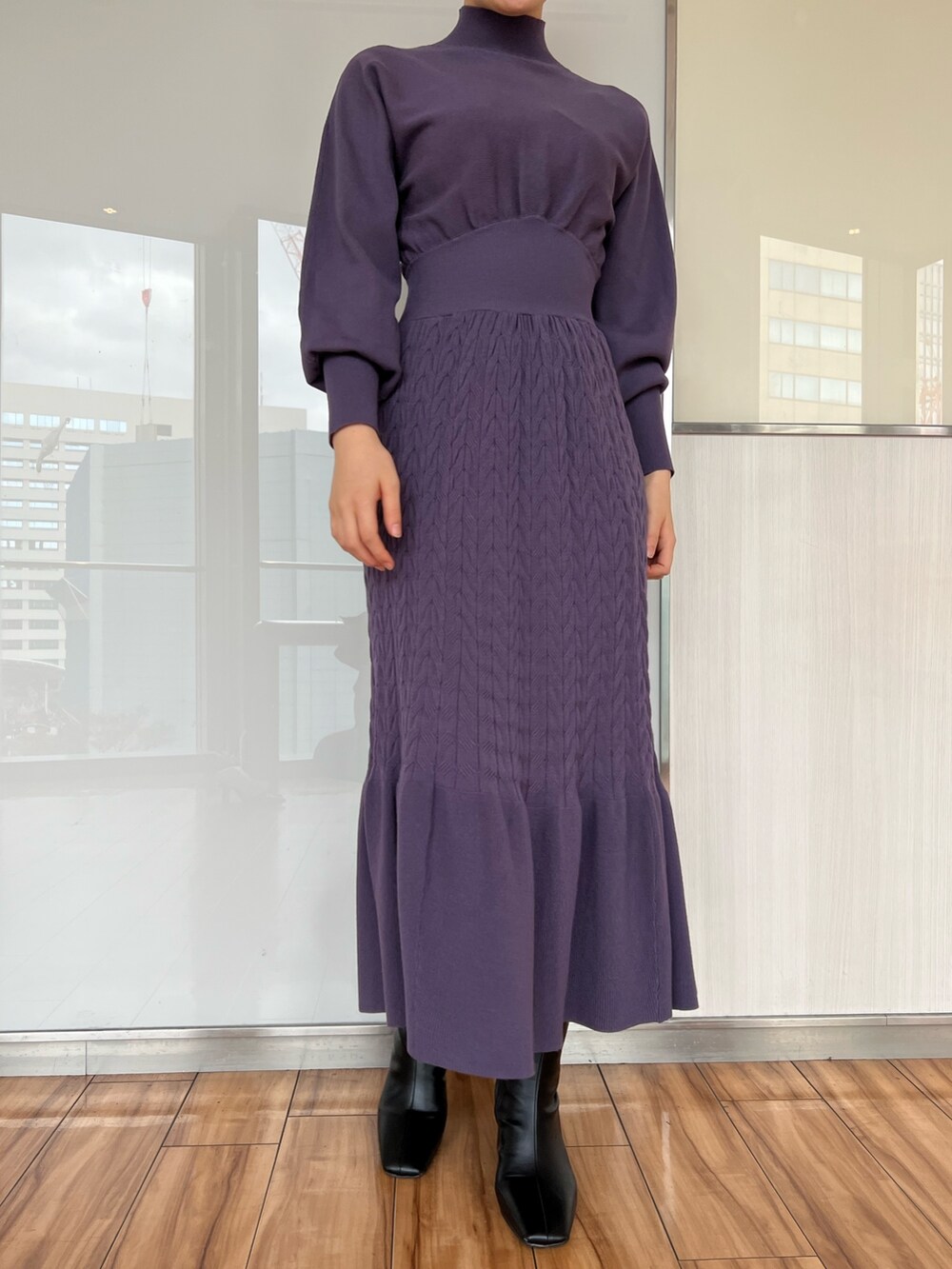 ブラック系のダウンジャケット/コート、ブラック系のブーツ、パープル系のワンピースを着用したレディースの冬コーディネートの10枚目の写真