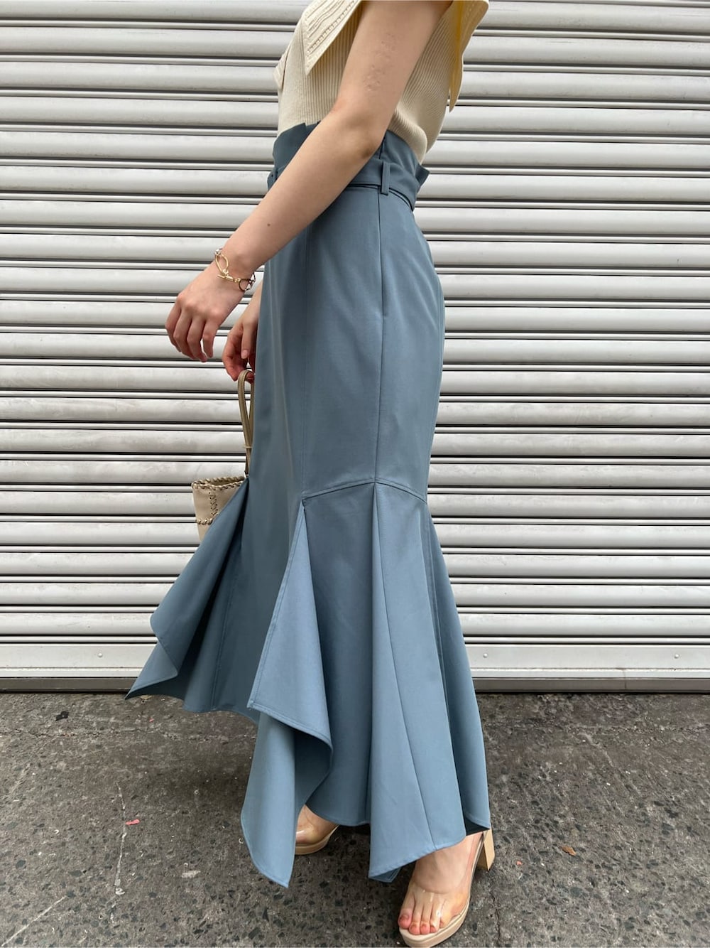 その他のパンプス、ホワイト系のショルダーバッグ、ブルー系のスカートを着用したレディースの春コーディネートの8枚目の写真