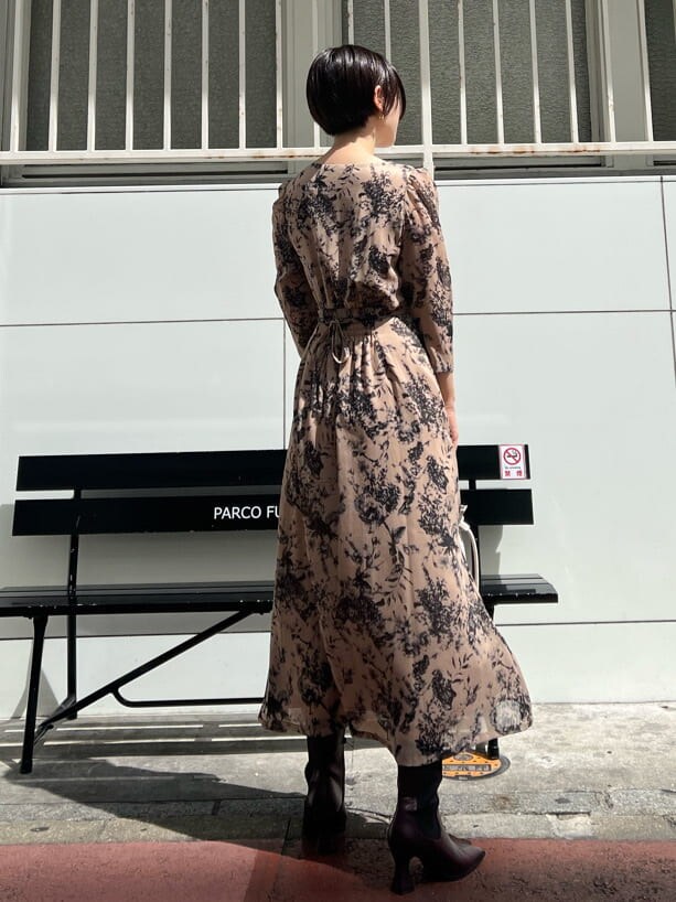 レッド系のブーツ、ホワイト系のカーディガン/ボレロ、ホワイト系のハンドバッグを着用したレディースの秋コーディネートの7枚目の写真