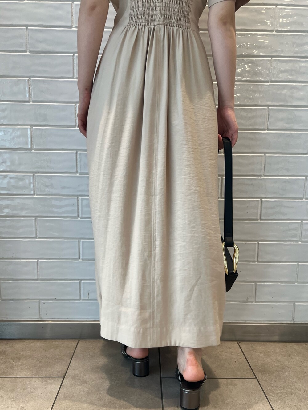 ベージュ系のワンピース、ブラック系のショルダーバッグ、その他のサンダルを着用したレディースの夏コーディネートの10枚目の写真