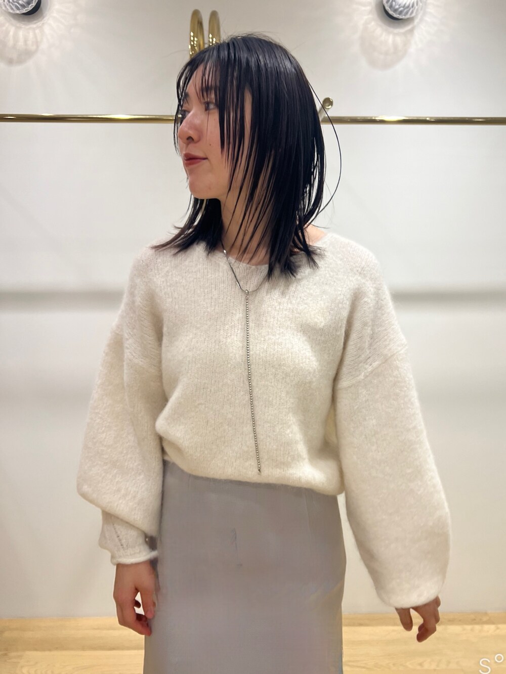 ホワイト系のニット/セーター、グレー系のブルゾン、ブラック系のブーツを着用したレディースの冬コーディネートの3枚目の写真