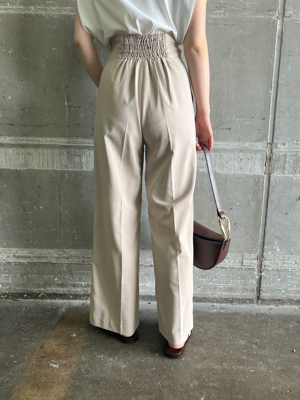 ブラウン系のサンダル、ベージュ系のハンドバッグ、ホワイト系のニット/セーターを着用したレディースの夏コーディネートの10枚目の写真