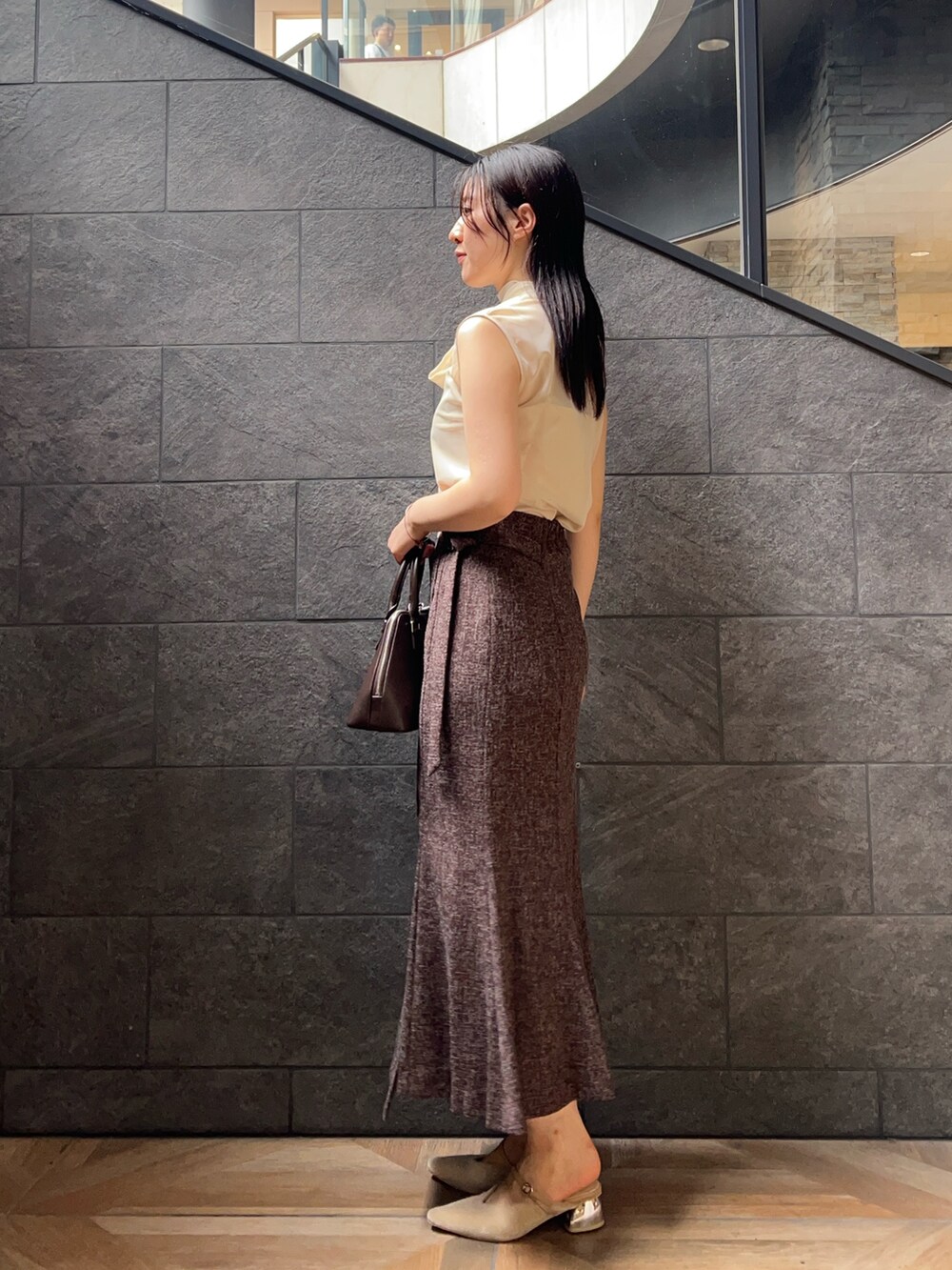 ブラウン系のボストンバッグ、ホワイト系のシャツ/ブラウス、ブラウン系のスカートを着用したレディースの夏コーディネートの2枚目の写真