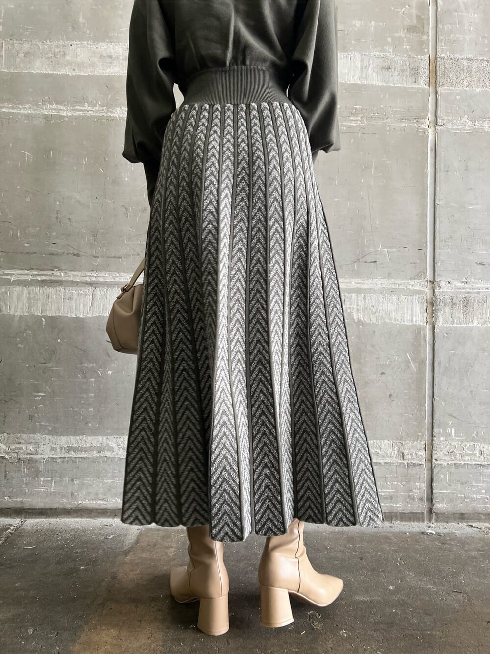 ベージュ系のブーツ、ベージュ系のハンドバッグ、ベージュ系のワンピースを着用したレディースの秋コーディネートの10枚目の写真