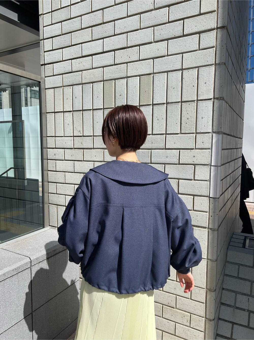 ブルー系のブルゾン、イエロー系のスカート、ベージュ系のスニーカーを着用したレディースの春コーディネートの5枚目の写真