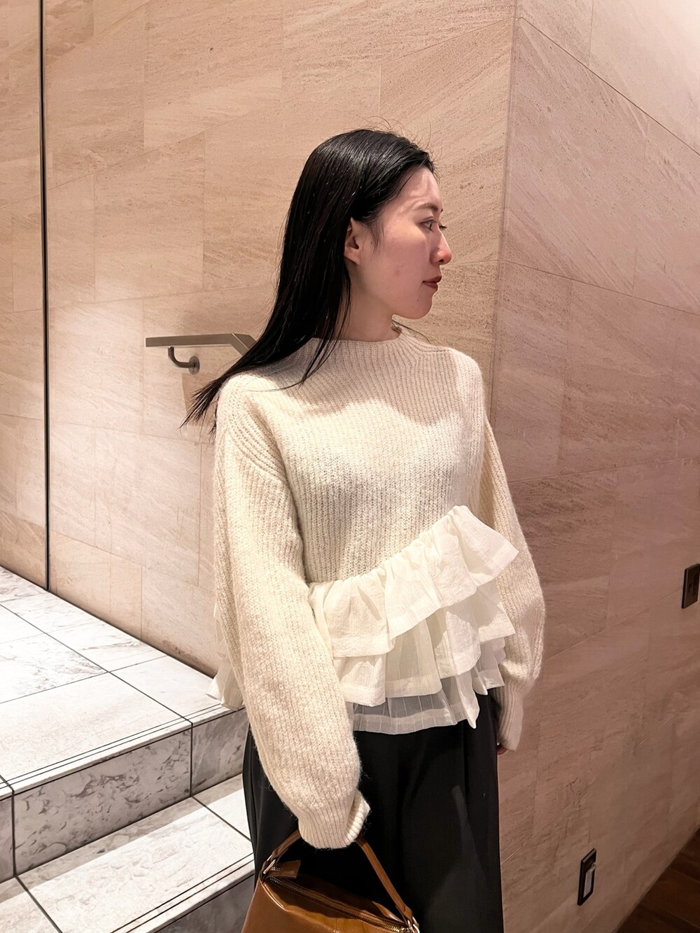 ホワイト系のニット/セーター、グレー系のその他パンツ、イエロー系のハンドバッグを着用したレディースの冬コーディネートの2枚目の写真