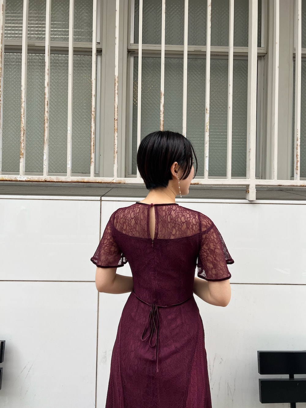 ホワイト系のノーカラーコート、レッド系のドレス、ベージュ系のパンプスを着用したレディースの冬コーディネートの7枚目の写真