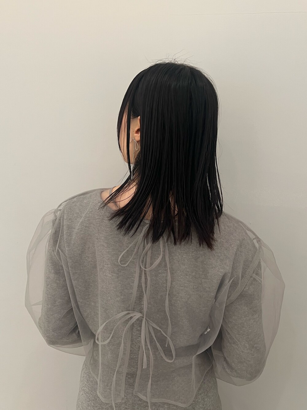 グレー系のワンピース、ブラック系のブーツ、ブラック系のショルダーバッグを着用したレディースの冬コーディネートの6枚目の写真