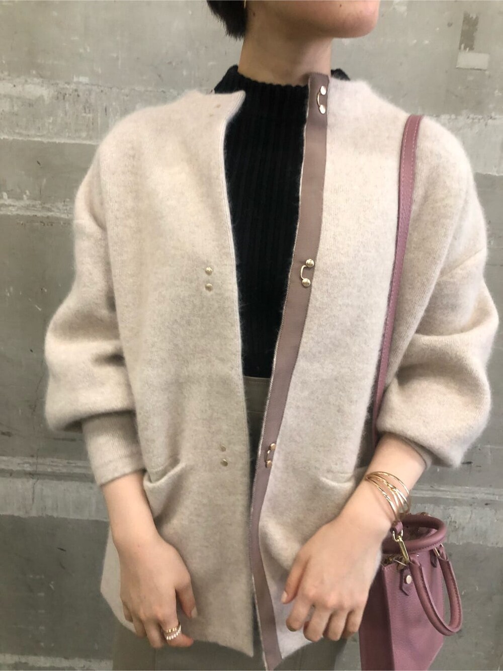 ピンク系のショルダーバッグ、ベージュ系のカーディガン/ボレロ、グレー系のスカートを着用したレディースの秋コーディネートの5枚目の写真