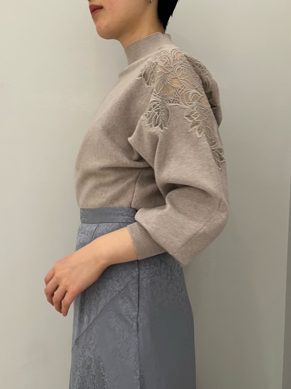 ブルー系のスカート、レッド系のブーツ、グレー系のニット/セーターを着用したレディースの冬コーディネートの3枚目の写真