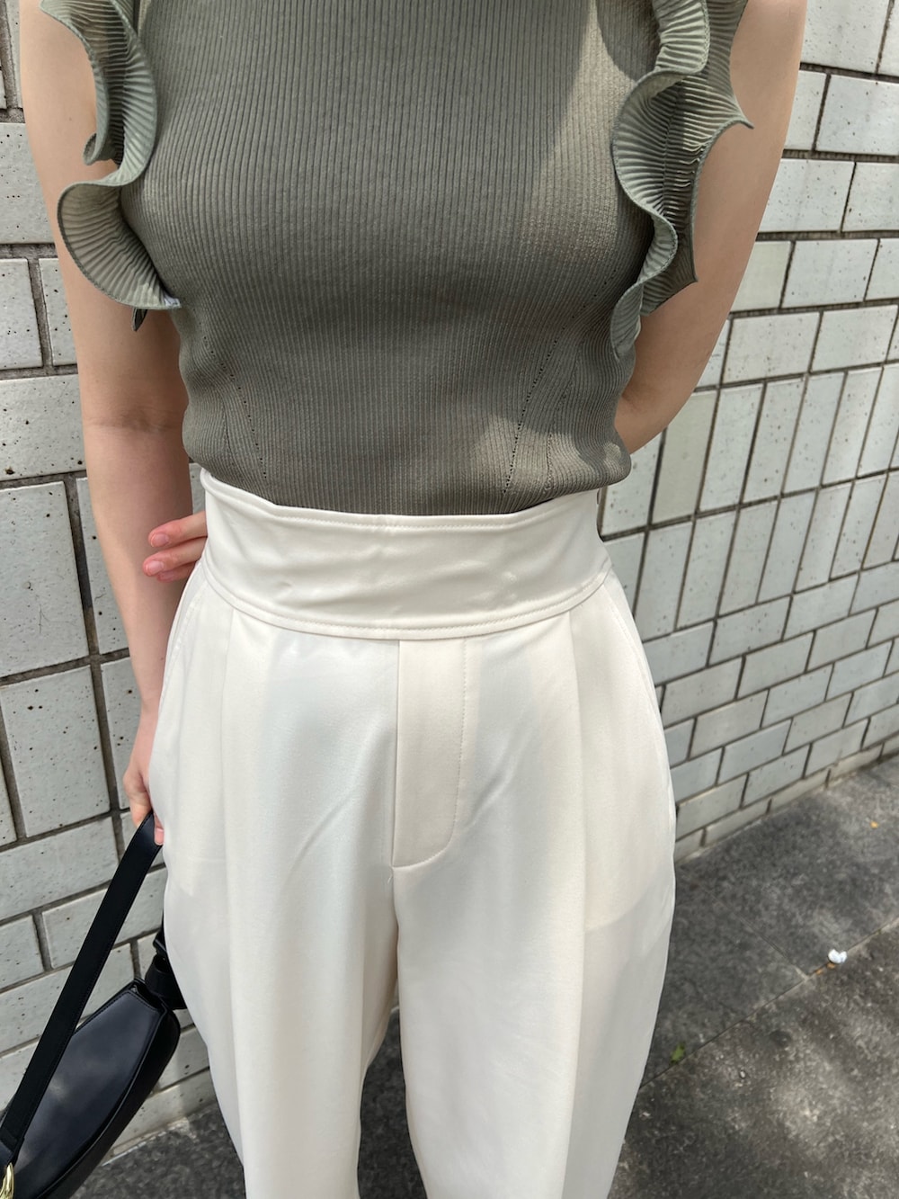 グリーン系のニット/セーター、ホワイト系のその他パンツ、ブラック系のサンダルを着用したレディースの春コーディネートの8枚目の写真