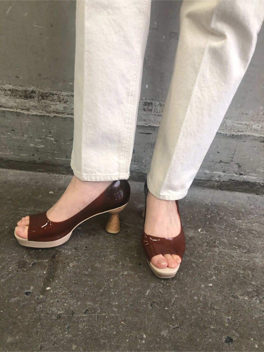 ブラウン系のパンプス、パープル系のハンドバッグ、ホワイト系のニット/セーターを着用したレディースの冬コーディネートの6枚目の写真