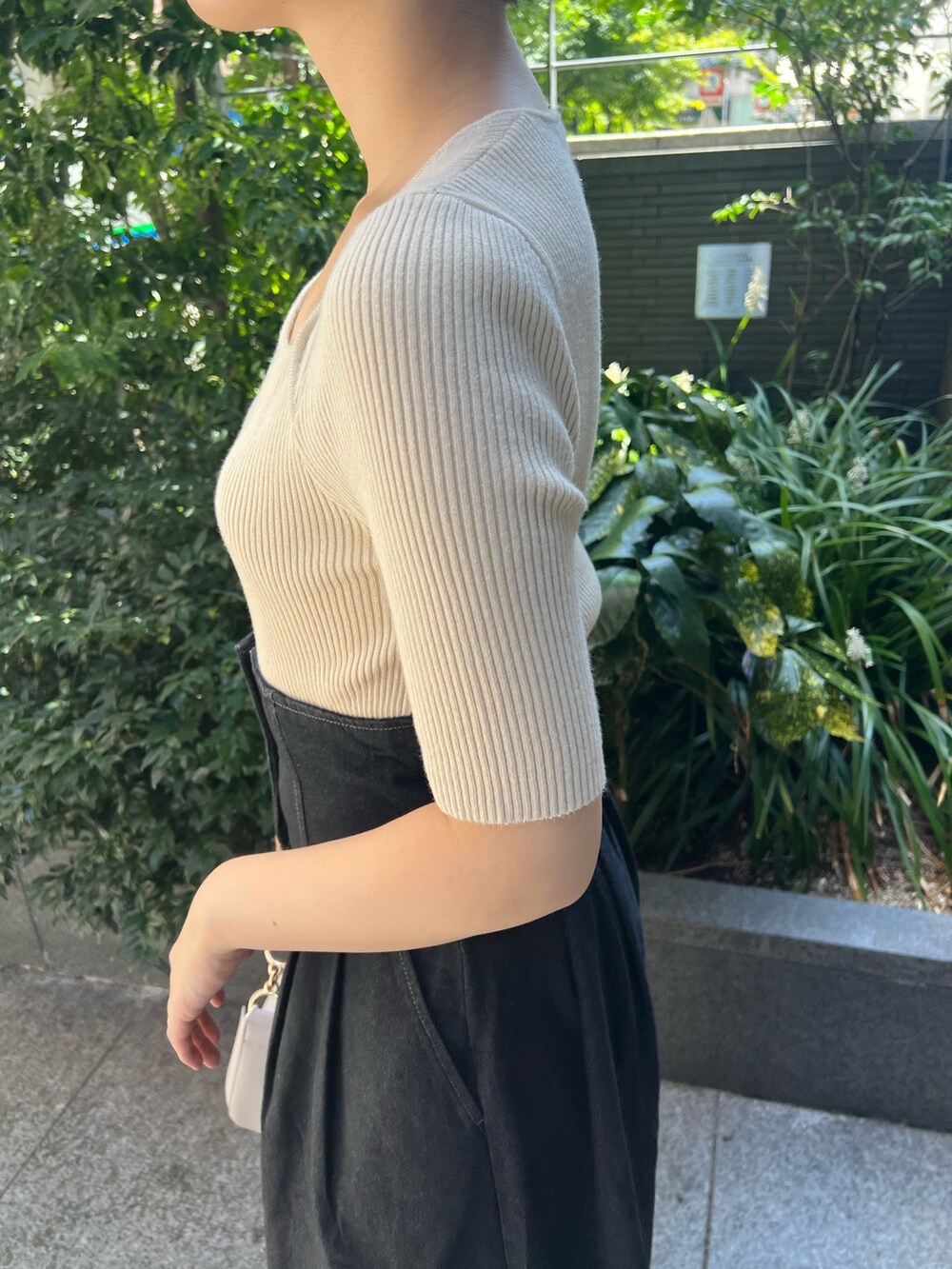 ブラック系のデニムジャケット、ブルー系のニット/セーター、ホワイト系のハンドバッグを着用したレディースの秋コーディネートの9枚目の写真