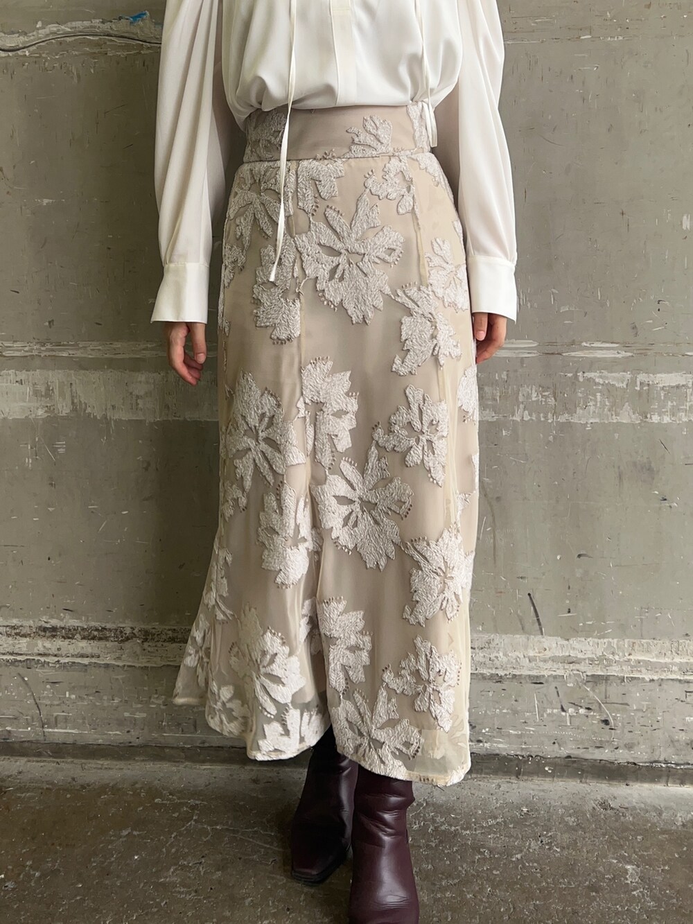 ベージュ系のスカート、ホワイト系のシャツ/ブラウス、ゴールド系のピアス(両耳用)を着用したレディースの秋コーディネートの5枚目の写真