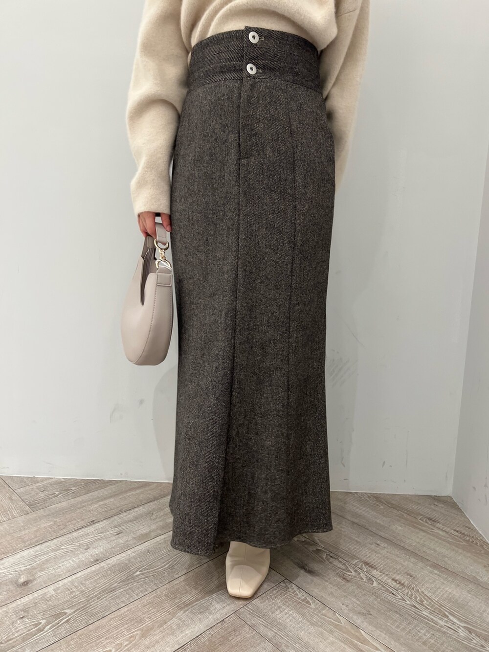 ブラウン系のスカート、ホワイト系のハンドバッグ、ホワイト系のパーカーを着用したレディースの秋コーディネートの9枚目の写真