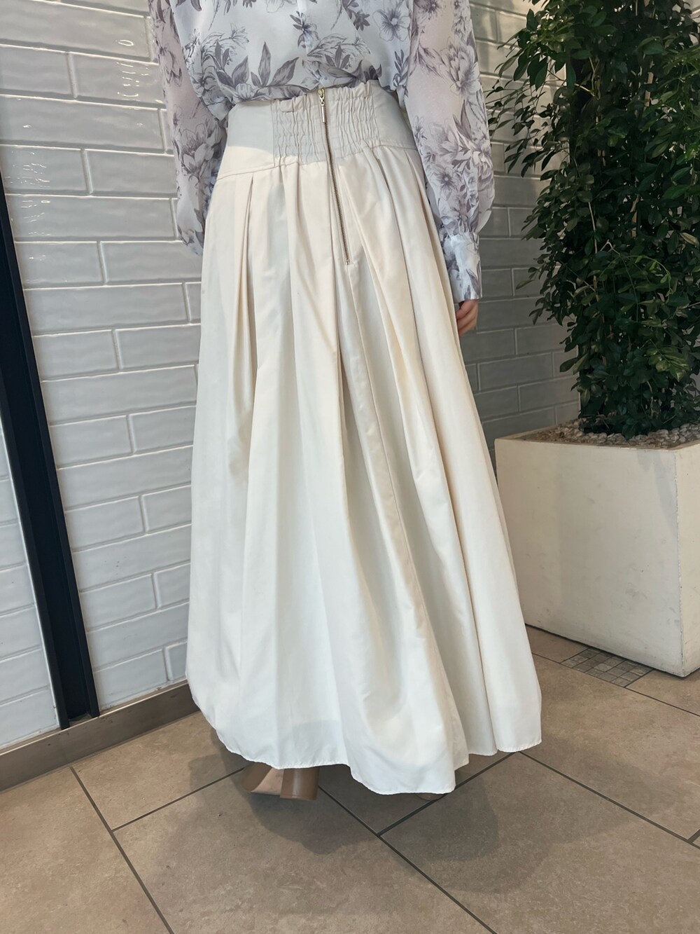 ホワイト系のスカート、ベージュ系のブーツ、ブラウン系のシャツ/ブラウスを着用したレディースの冬コーディネートの8枚目の写真