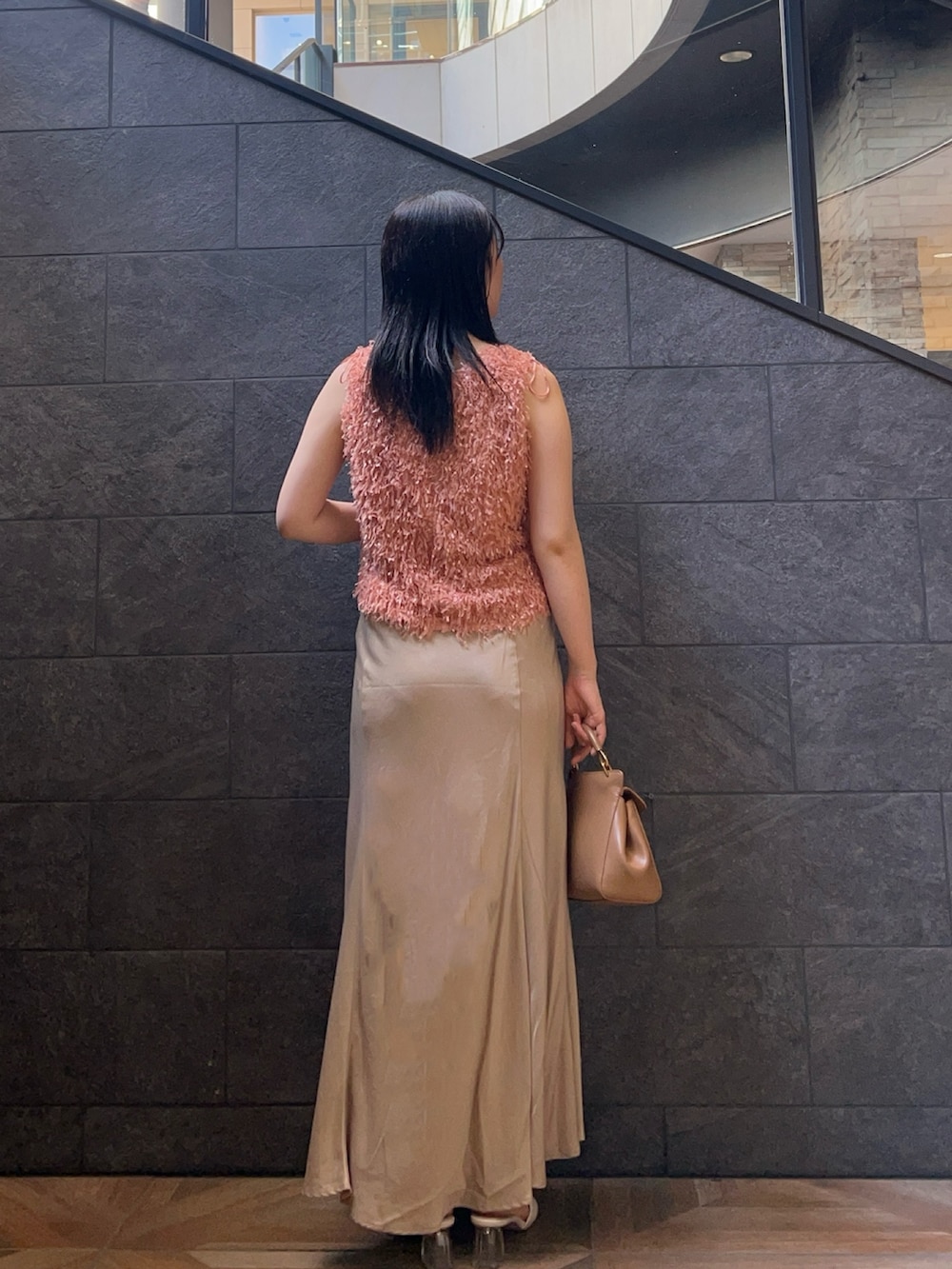 オレンジ系のTシャツ/カットソー、ベージュ系のスカート、ホワイト系のサンダルを着用したレディースの夏コーディネートの3枚目の写真