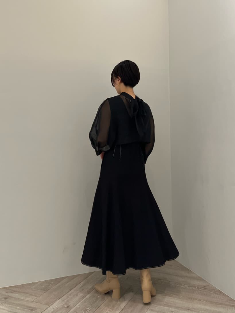 ベージュ系のブーツ、ブラック系のワンピース、ブラック系のハンドバッグを着用したレディースの秋コーディネートの3枚目の写真