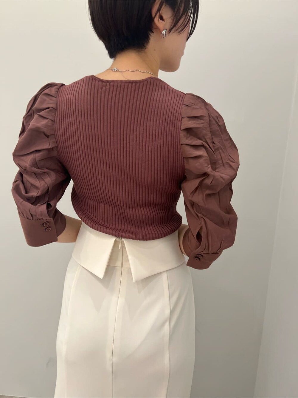 ブラウン系のパンプス、ホワイト系のスカート、ブラウン系のニット/セーターを着用したレディースの夏コーディネートの6枚目の写真