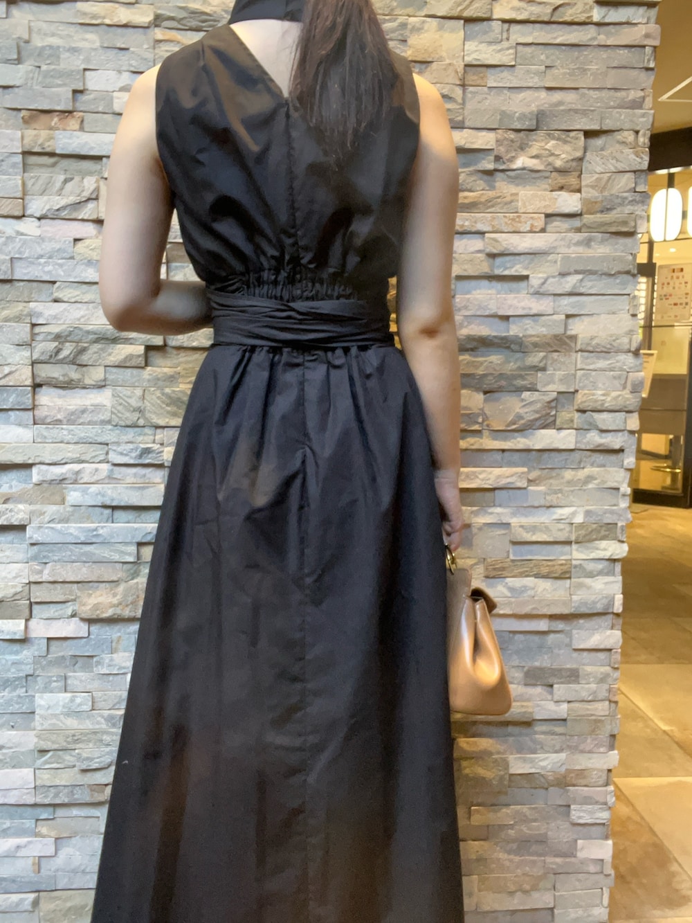 ブラック系のワンピース、ホワイト系のサンダル、レッド系のハンドバッグを着用したレディースの夏コーディネートの6枚目の写真